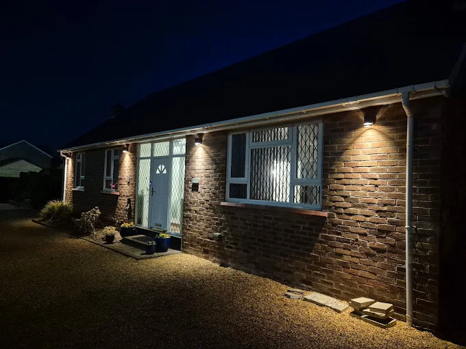 Bungalow in Liverpool lit by newly installed outdoor wall lights at night